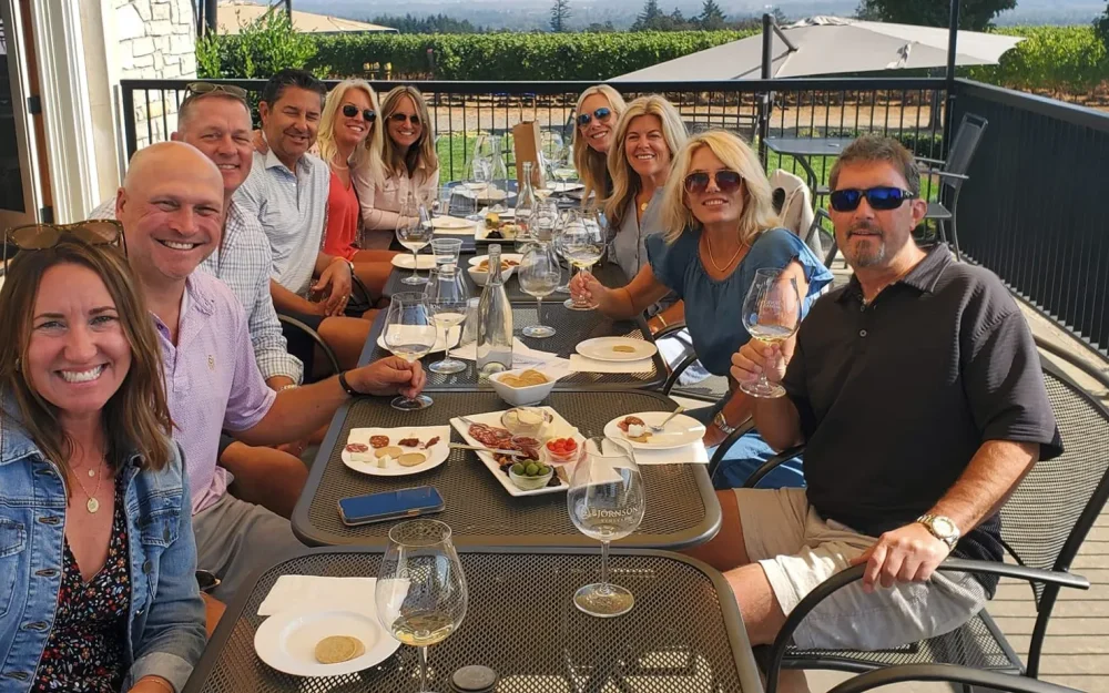 A group of friends enjoying an outdoor wine tasting on the deck at Bjornson Vineyard in Eola-Amity Hills, Willamette Valley, Oregon